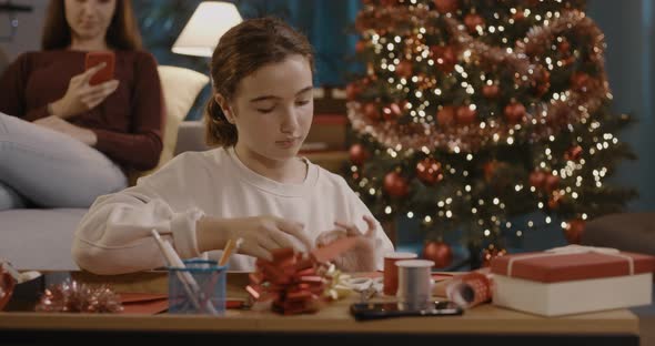 Cute girl writing a Christmas card at home