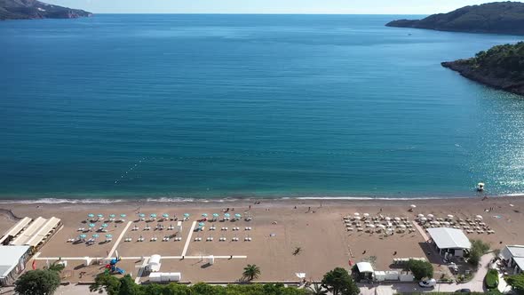Sea beach fly over to the sea on a sunny day. Petrovac, Montenegro big beach with sand and a blue se alt