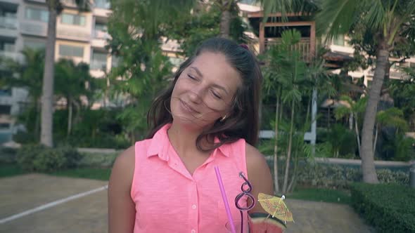 Pretty Long Haired Woman Stands in Hotel Yard at Green Palms alt