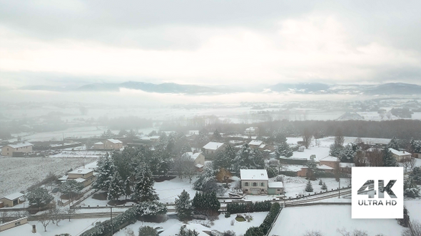 Aerial Pedestal View Of Snowy French Village And Mountains