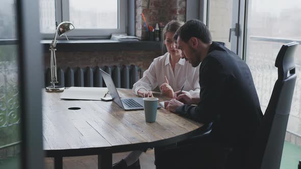 Colleagues A Man and a Woman are Discussing a Project in a Meeting Room alt