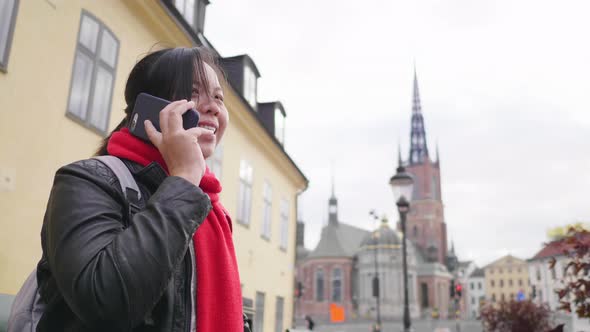 Happy Asian woman wearing winter outfits standing and having a call in town alt