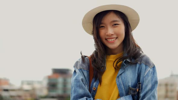 Happy young Asian woman smiling looking at the camera.