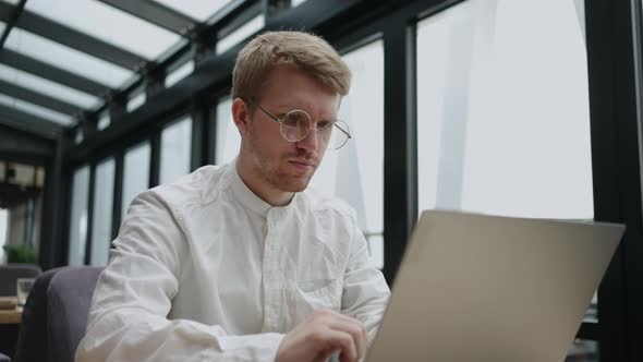 Modern Coworking Space for Freelancer and Worker Remote Adult Man is Working with Laptop in Office alt