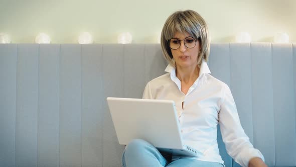 An Elderly Businesswoman Indignantly Communicates with Her Employees on the Phone and Solves