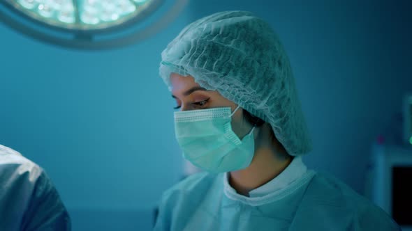 A Woman Wearing a Doctors Mask and a Hairnet is in