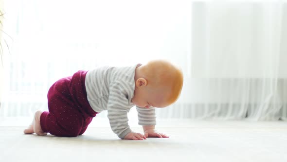 The Baby Girl Learns To Crawl, the First Attempts To Crawl. Baby Crawls To the Camera, Smiling and