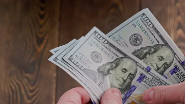 Caucasian Hand Counting Small Stack of Hundred Us Dollar Banknotes