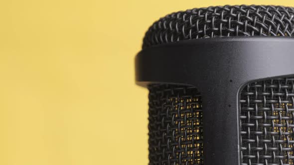 Studio Condenser Microphone Rotates on Yellow Background with Place for Text alt