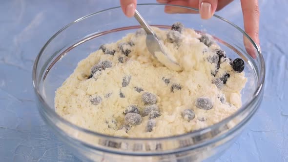 Female Hands Making Blueberry Scone Dough in Glass Bowl