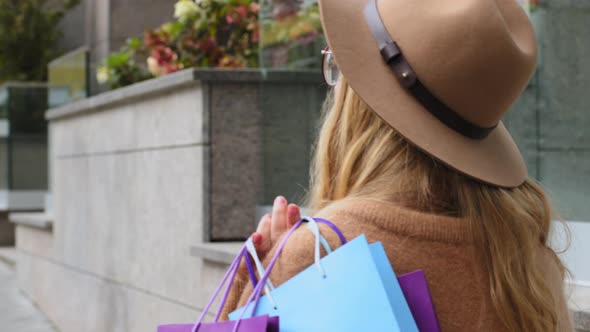 Back View Millennial Girl Going in City Street Young Woman Holding Colorful Packages Caucasian alt
