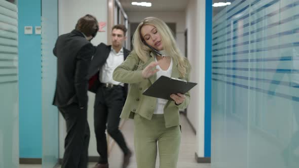 Portrait of Busy Serious Confident Beautiful Female CEO Walking in Office Hallway Talking on the alt