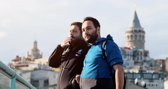 Two men are talking on the terrace in front of Galata Tower.