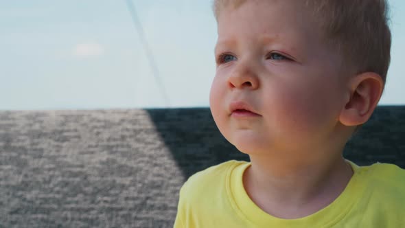 Somnolent Toddler Boy in Yellow Tshirt Yawns in Ropeway Car alt