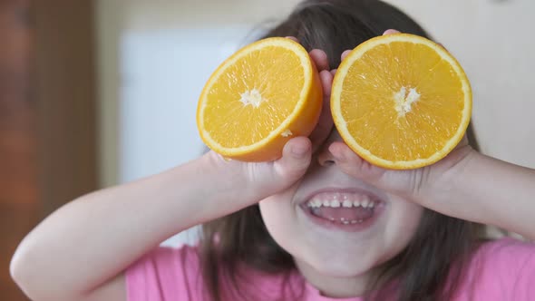 Oranges instead of eyes. Funny child with orange. alt