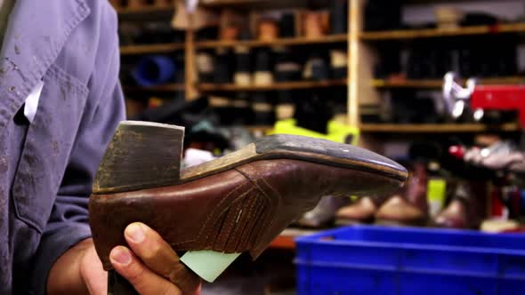 Cobbler hammering on shoe sole alt