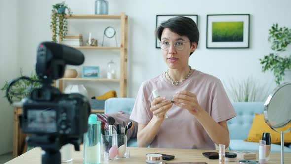 Creative Blogger Recording Video for Online Vlog Holding Makeup Products and Speaking alt
