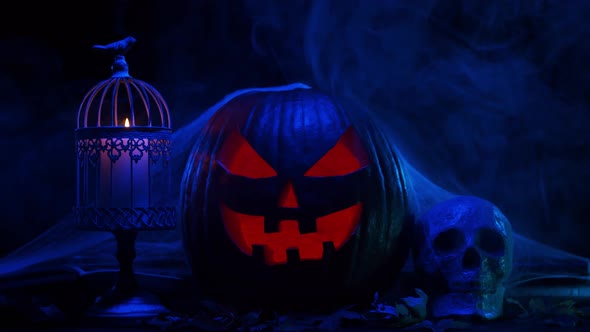 Scary laughing pumpkin and an old skull over the frightening gothic background. alt