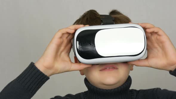 Teenager Boy with Virtual Reality or Vr Glasses on His Head and Having Fun on a White Background in