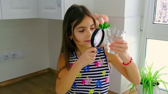 The Child Examines the Water with a Magnifying Glass alt