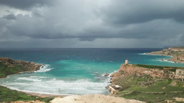 AERIAL: Ghajn Tuffieha Bay with Sandy Beach and Upcoming Storm alt