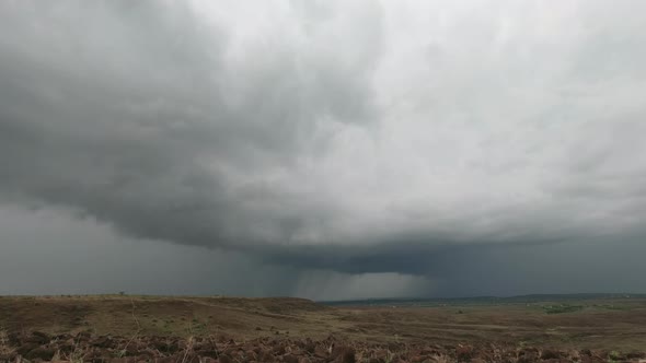 Gathering of a  Huge Storm clouds in the  sky over the parched Grassland rocky landscape during the alt
