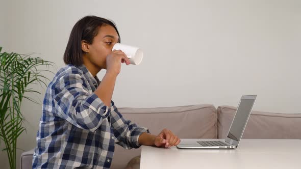 A Darkskinned Woman Communicates Online Via Video Link While Sitting at Home