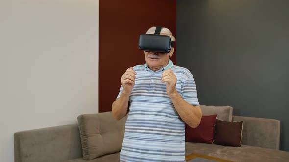 Senior Grandfather Man in Virtual Headset Glasses Watching Amazing 3D Video in 360 Vr Helmet at Home alt
