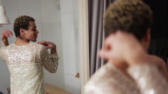 A Man in a Dress Admires Himself Standing in Front the Mirror Slowly Dancing alt