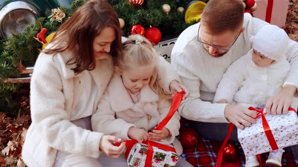 Parents with Children Open Christmas Gifts