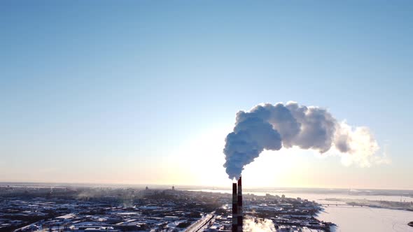 Chimneys of a Factory or Power Plant Produce Smoke at Sunrise Aerial View From a Drone