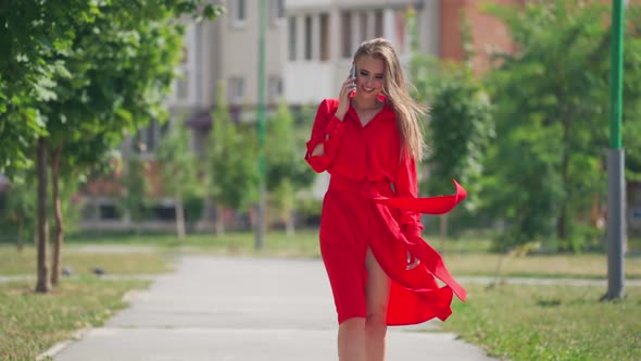 Woman talking on mobile phone. Happy smiling woman making phone call outdoor in the city alt