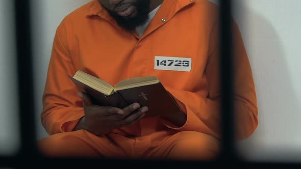 Black Male Prisoner Reading Holy Bible in Cell, Hope for Forgiveness, Penance alt