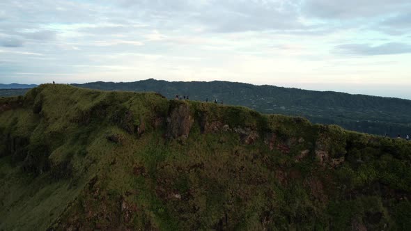 aerial of people trekking on a ridge near crater of Mount Batur volcano at sunrise in Bali Indonesia alt