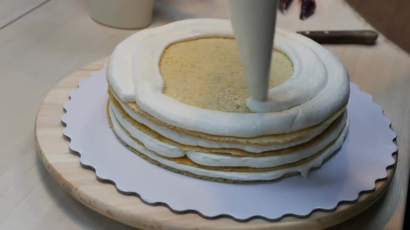 Applying a Thick Layer of Cream to a Sponge Cake in a Multilayer Cake