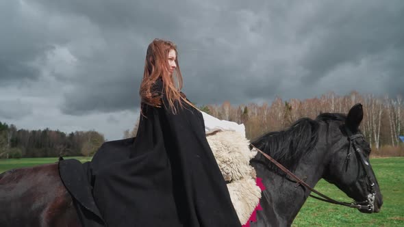 Beautiful Female in a Medieval Dress Riding a Horse Through a Greenfield Medieval Scene  Slow Motion alt