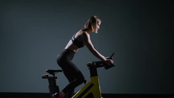 Cycle Training Young Woman is Engaged in Fitness on a Spin Bike Performs Aerobic Endurance Training alt