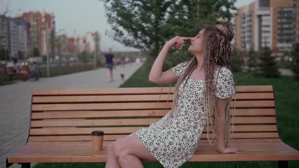 Young Girl with Dreadlocks Posing on a Bench