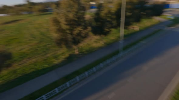 Aerial Panorama View Speed Motorcycle Black Biker Outfit Riding on City Street Road Nature Sunlight alt