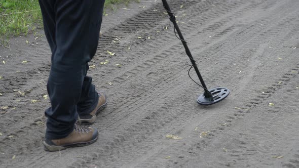 Treasure Hunter on Road with Electronic Metal Detector, Scanning Ground Road