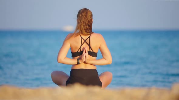 Young Woman Practicing Yoga at the Beach