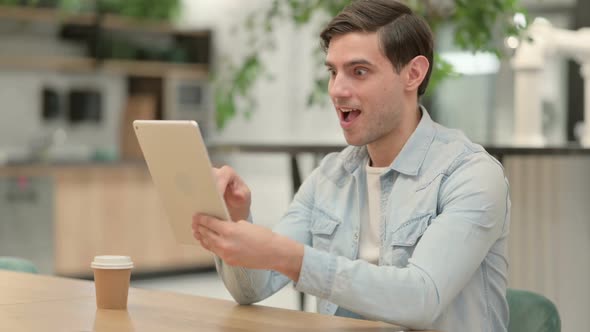 Successful Businessman Celebrating on Tablet at Work alt
