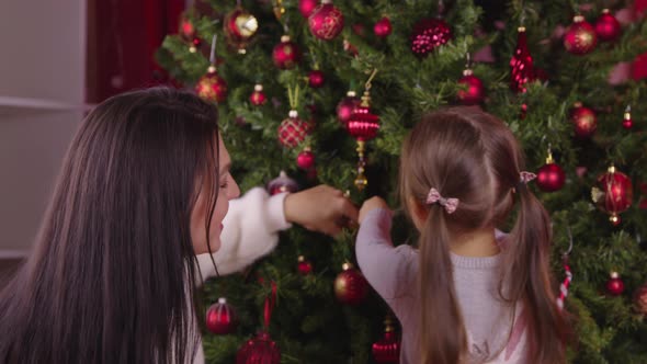 Young Beautiful Mother and Cute Little Daughter Decorating Christmas Tree, Xmas