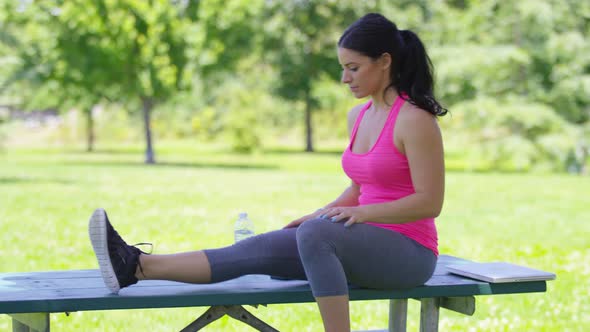 Athletic woman at park stretches before run