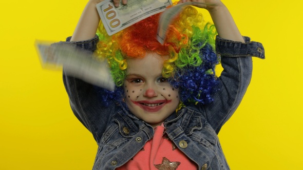 Little Child Girl Clown in Wig Making Silly Faces, Having Fun with Money Banknotes Dollar Cash alt