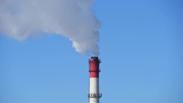 Chimney of Power Plant on Blue Sky White Vapor From Red Tube