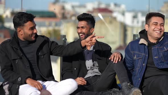 Joyful Young Handsome Middle Eastern Men Talking Laughing Making Jokes Sitting on Rooftop in alt