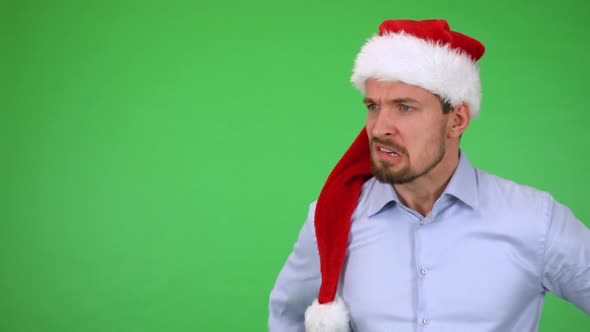 A Young Handsome Man in a Christmas Hat Acts Angry - Green Screen Studio alt