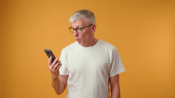 Worried Senior Man Old Employee Looking at Mobile Phone