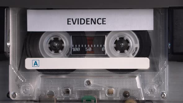 Cassette Tape With Evidence Audio Recording Rolling in Vintage Deck Player alt
